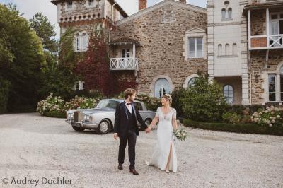 Table en bois dressée avec vaisselle, verres, fruits et fleurs, dans une salle lumineuse au décor chaleureux.