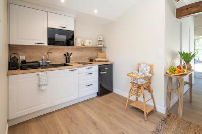 Table en bois dressée avec vaisselle, verres, fruits et fleurs, dans une salle lumineuse au décor chaleureux.
