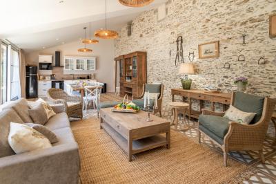 Table en bois dressée avec vaisselle, verres, fruits et fleurs, dans une salle lumineuse au décor chaleureux.