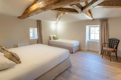 Table en bois dressée avec vaisselle, verres, fruits et fleurs, dans une salle lumineuse au décor chaleureux.