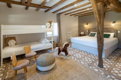 Table en bois dressée avec vaisselle, verres, fruits et fleurs, dans une salle lumineuse au décor chaleureux.