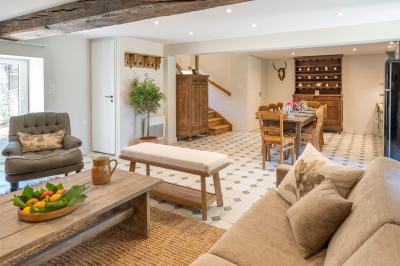 Table en bois dressée avec vaisselle, verres, fruits et fleurs, dans une salle lumineuse au décor chaleureux.