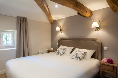 Table en bois dressée avec vaisselle, verres, fruits et fleurs, dans une salle lumineuse au décor chaleureux.