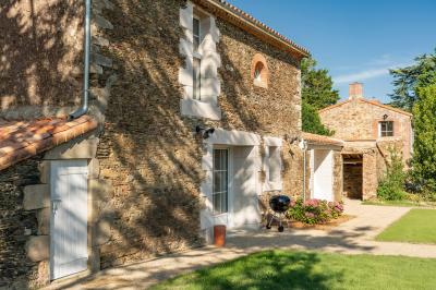 Table en bois dressée avec vaisselle, verres, fruits et fleurs, dans une salle lumineuse au décor chaleureux.