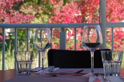 Plateau de fromage avec raisins et pain en arrière-plan, un verre de vin rosé au premier plan.