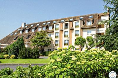 Salle de sport avec vélos d'appartement, tapis de course, ballon d'exercice et équipements de musculation.