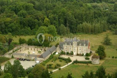 Deux personnes en costume historique s'affrontent à l'épée dans une cour devant un mur en pierre avec des arches.