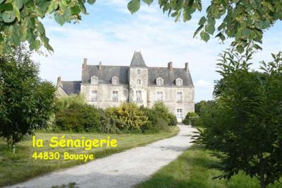 Deux personnes en costume historique s'affrontent à l'épée dans une cour devant un mur en pierre avec des arches.