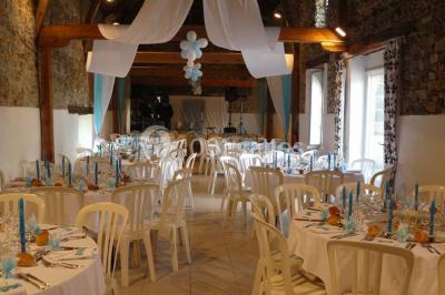 Deux personnes en costume historique s'affrontent à l'épée dans une cour devant un mur en pierre avec des arches.