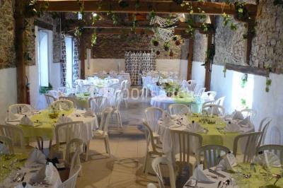 Deux personnes en costume historique s'affrontent à l'épée dans une cour devant un mur en pierre avec des arches.