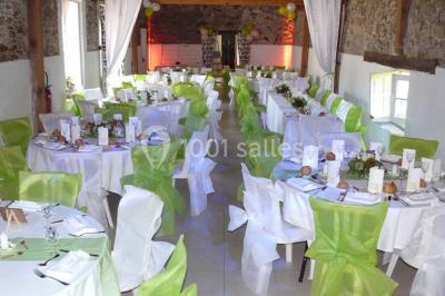 Deux personnes en costume historique s'affrontent à l'épée dans une cour devant un mur en pierre avec des arches.