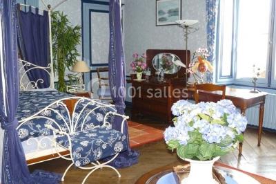 Deux personnes en costume historique s'affrontent à l'épée dans une cour devant un mur en pierre avec des arches.