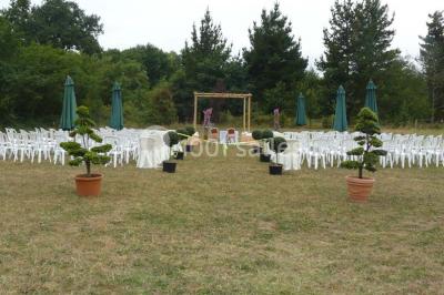 Deux personnes en costume historique s'affrontent à l'épée dans une cour devant un mur en pierre avec des arches.