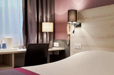 Salle de restaurant moderne avec tables alignées, chaises noires et décoration murale colorée sur le thème de la…