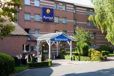 Salle de restaurant moderne avec tables alignées, chaises noires et décoration murale colorée sur le thème de la…