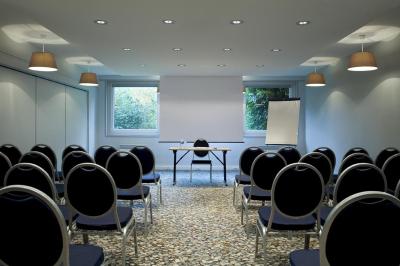 Salle de restaurant moderne avec tables alignées, chaises noires et décoration murale colorée sur le thème de la…