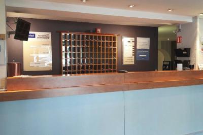 Salle de restaurant moderne avec tables alignées, chaises noires et décoration murale colorée sur le thème de la…