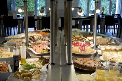 Salle de restaurant moderne avec tables alignées, chaises noires et décoration murale colorée sur le thème de la…