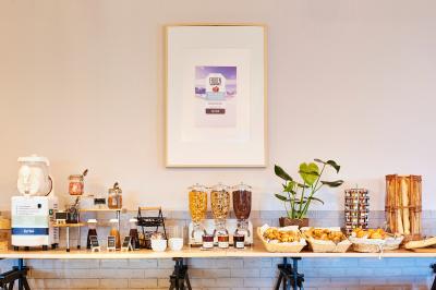 Salle de restaurant moderne avec tables alignées, chaises noires et décoration murale colorée sur le thème de la…
