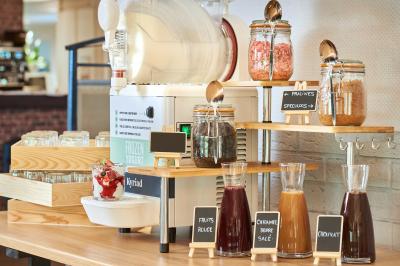 Salle de restaurant moderne avec tables alignées, chaises noires et décoration murale colorée sur le thème de la…
