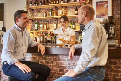 Salle de restaurant moderne avec tables alignées, chaises noires et décoration murale colorée sur le thème de la…
