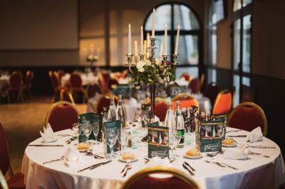 Salle de casino avec machines à sous illuminées, chaises noires et décor moderne sous un plafond sombre.