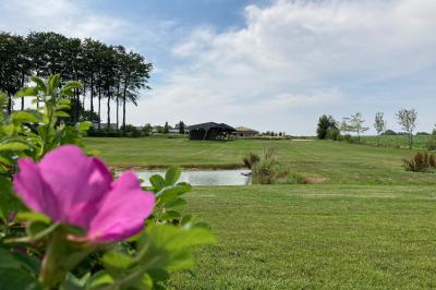 Vue aérienne d'un parc avec bâtiments numérotés, espaces verts, arbres, et un terrain de golf.