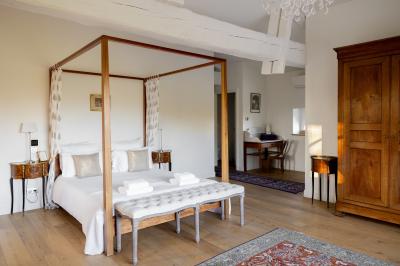 Miniature Suite Cèdre Grande maison en pierre entourée d'un jardin fleuri et arboré, sous un ciel clair.