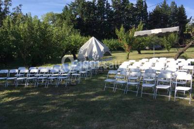 Plan de table sur un chevalet près de l'entrée d'une salle éclairée par des guirlandes lumineuses, ambiance festive.