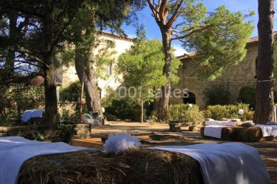 Plan de table sur un chevalet près de l'entrée d'une salle éclairée par des guirlandes lumineuses, ambiance festive.