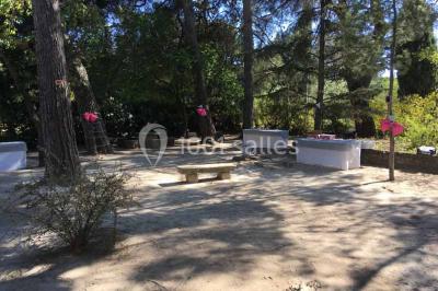 Plan de table sur un chevalet près de l'entrée d'une salle éclairée par des guirlandes lumineuses, ambiance festive.