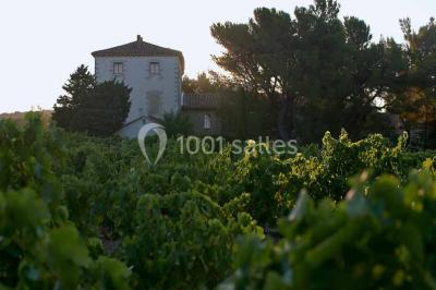 Plan de table sur un chevalet près de l'entrée d'une salle éclairée par des guirlandes lumineuses, ambiance festive.