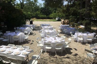 Plan de table sur un chevalet près de l'entrée d'une salle éclairée par des guirlandes lumineuses, ambiance festive.