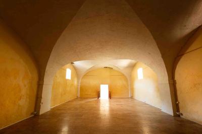 Plan de table sur un chevalet près de l'entrée d'une salle éclairée par des guirlandes lumineuses, ambiance festive.