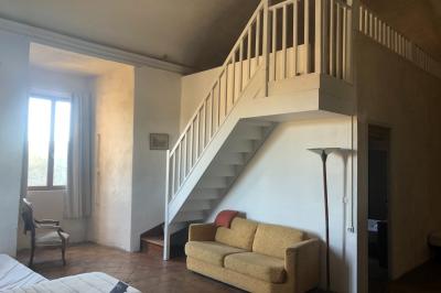 Plan de table sur un chevalet près de l'entrée d'une salle éclairée par des guirlandes lumineuses, ambiance festive.