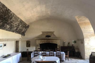 Plan de table sur un chevalet près de l'entrée d'une salle éclairée par des guirlandes lumineuses, ambiance festive.