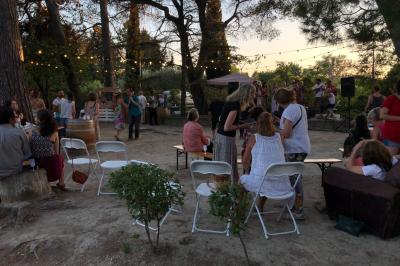 Plan de table sur un chevalet près de l'entrée d'une salle éclairée par des guirlandes lumineuses, ambiance festive.