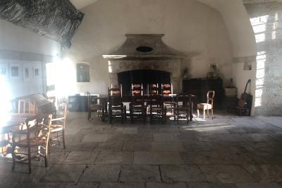 Plan de table sur un chevalet près de l'entrée d'une salle éclairée par des guirlandes lumineuses, ambiance festive.