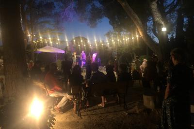 Plan de table sur un chevalet près de l'entrée d'une salle éclairée par des guirlandes lumineuses, ambiance festive.