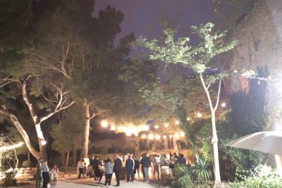 Plan de table sur un chevalet près de l'entrée d'une salle éclairée par des guirlandes lumineuses, ambiance festive.