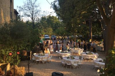 Plan de table sur un chevalet près de l'entrée d'une salle éclairée par des guirlandes lumineuses, ambiance festive.