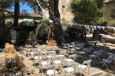Plan de table sur un chevalet près de l'entrée d'une salle éclairée par des guirlandes lumineuses, ambiance festive.