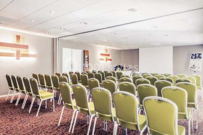 Salle de sport lumineuse avec tapis de course, vélos d'appartement et équipements de musculation.