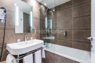 Salle de sport lumineuse avec tapis de course, vélos d'appartement et équipements de musculation.