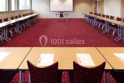 Salle de sport lumineuse avec tapis de course, vélos d'appartement et équipements de musculation.