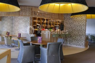 Salle de sport lumineuse avec tapis de course, vélos d'appartement et équipements de musculation.