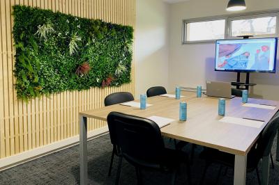 Salle de sport lumineuse avec tapis de course, vélos d'appartement et équipements de musculation.