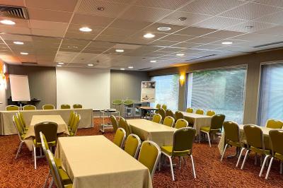 Salle de sport lumineuse avec tapis de course, vélos d'appartement et équipements de musculation.