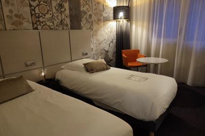 Salle de sport lumineuse avec tapis de course, vélos d'appartement et équipements de musculation.