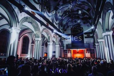 Ruines d'une abbaye gothique avec des arches et des fenêtres sans vitraux, entourées de végétation.
